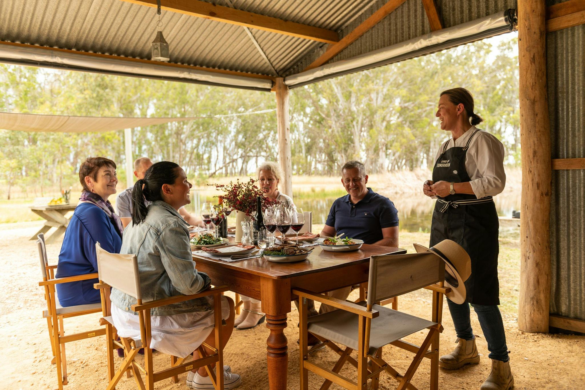 Coonawarra Experiences - A group of people enjoying a lunch in a rustic outdoor setting