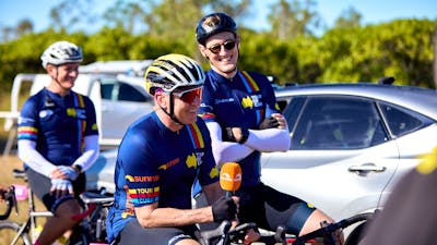 Mark Beretta and Mack Horton casually sitting on their bikes in cycle kit during Signature Tour '25