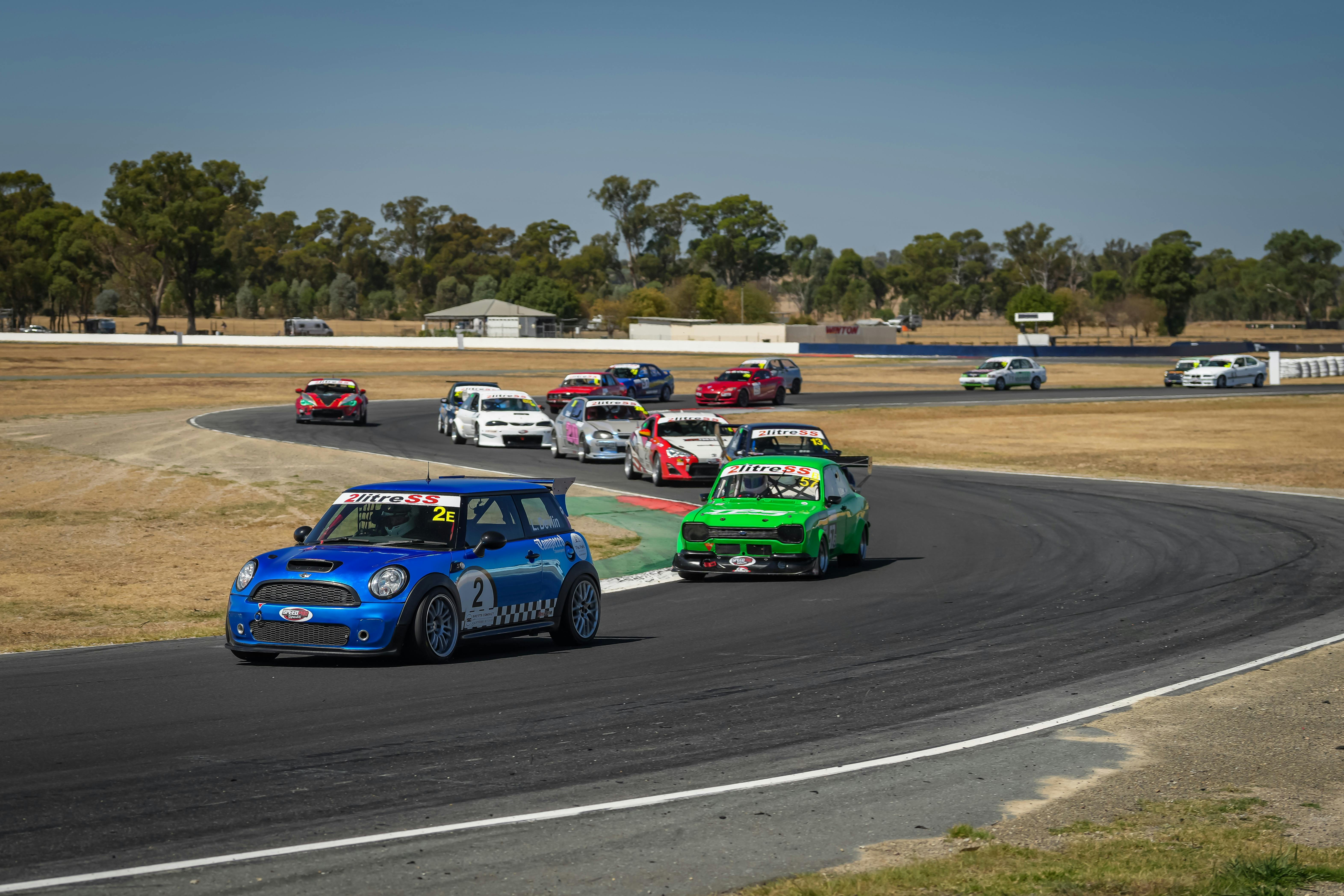 Cars going around a corner on a racetrack