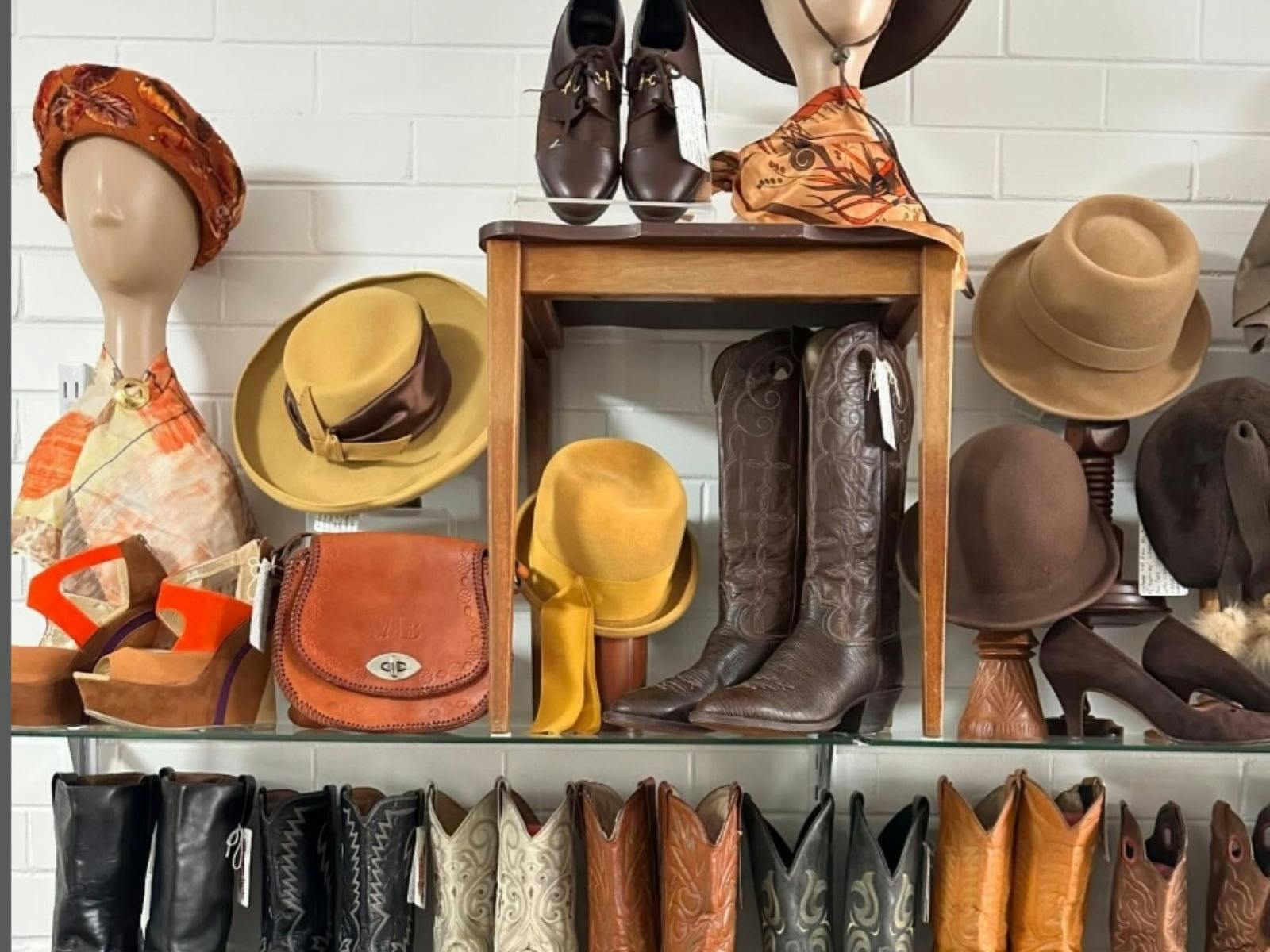 Cowboy boots and vintage style hats arranged on a rack