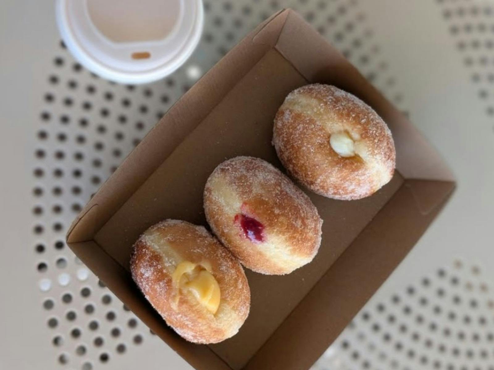 three doughnuts in a cardboard box from above