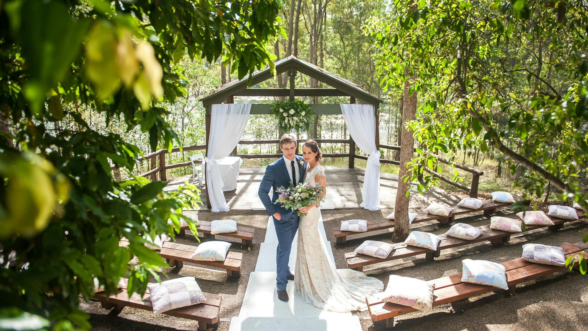 Bride and groom at the Lakeview wedding ceremony space surrounded by rainforest