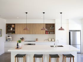 Modern kitchen with large island bench, pendant lights and island stools