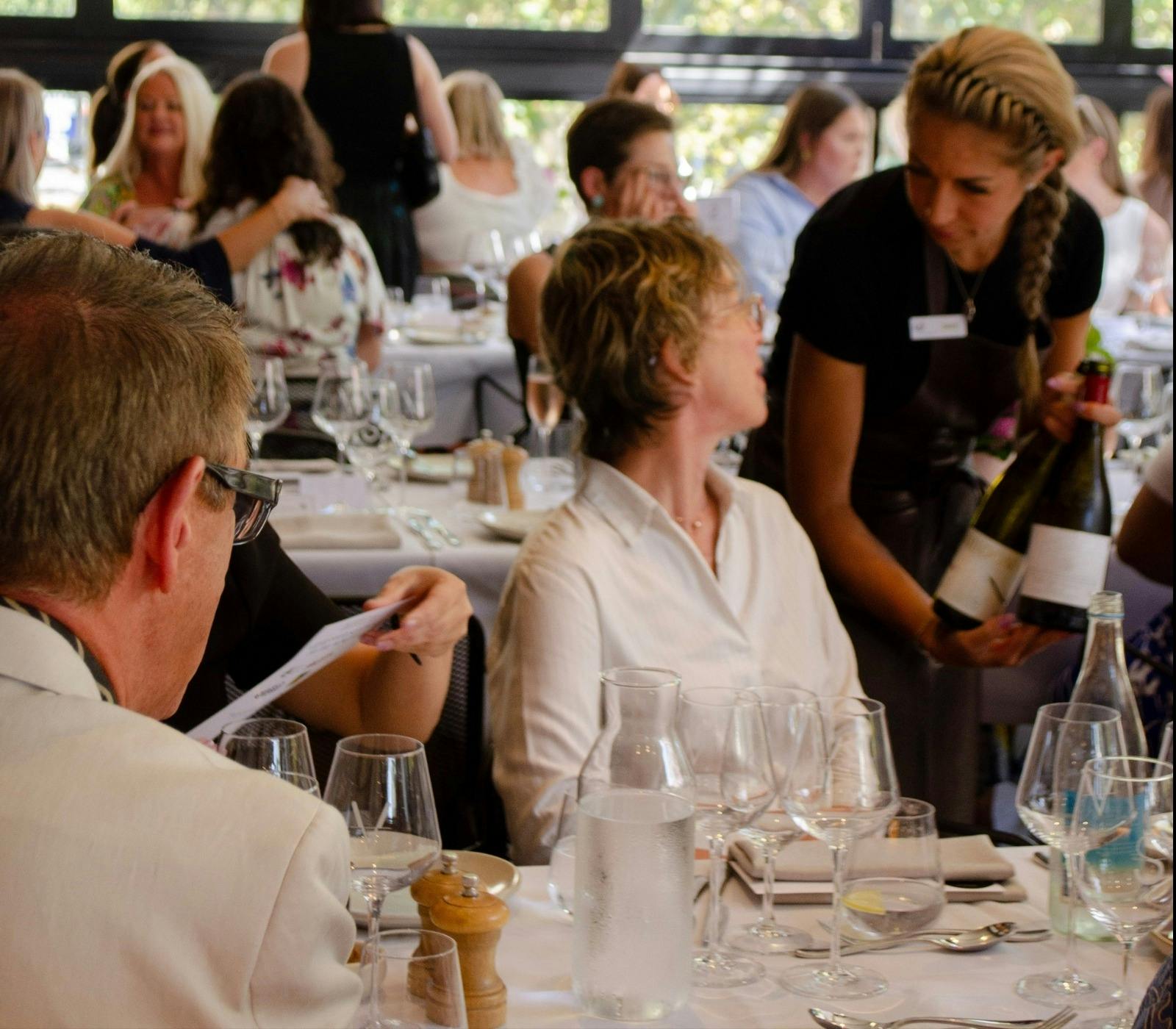 Waitress offering Wine to a customer