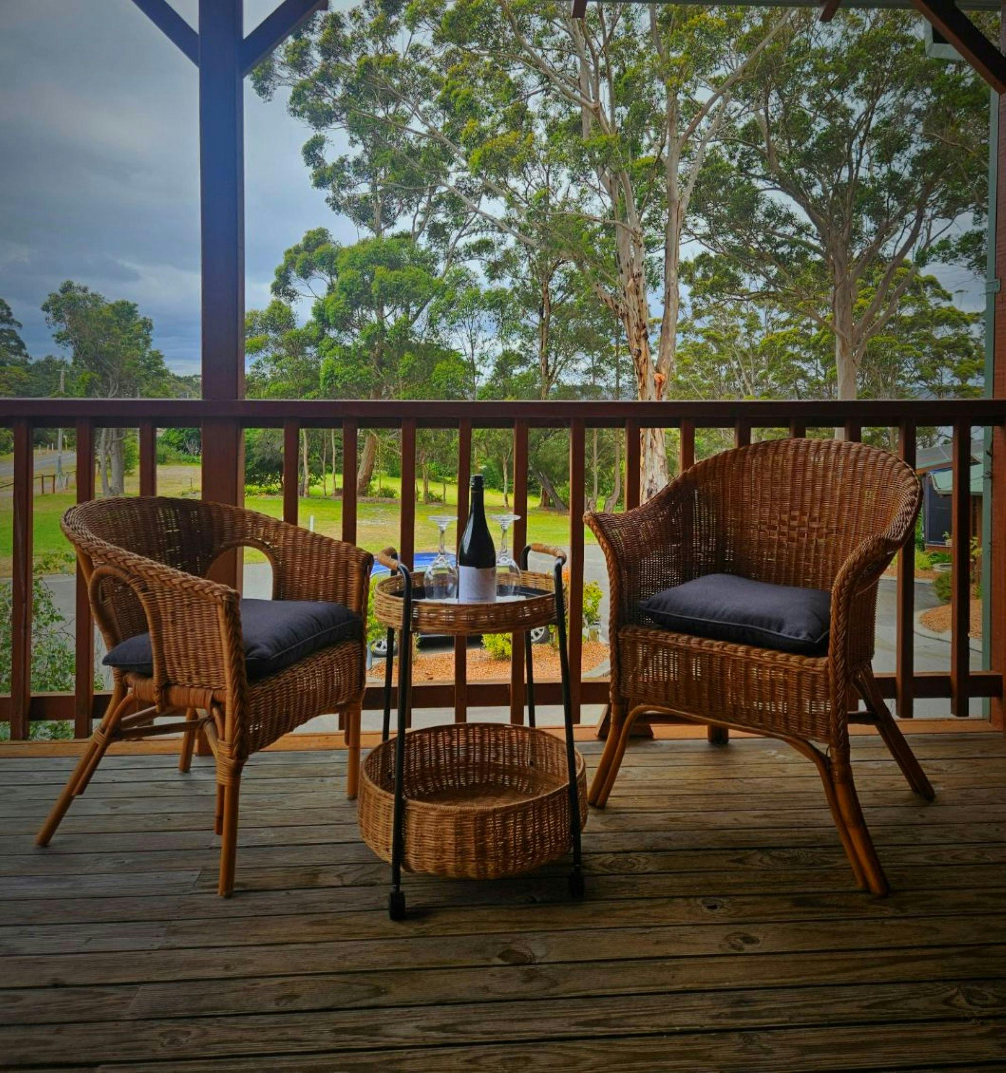 Suite balcony seating with views of Wilson Inlet and surrounding karri trees.