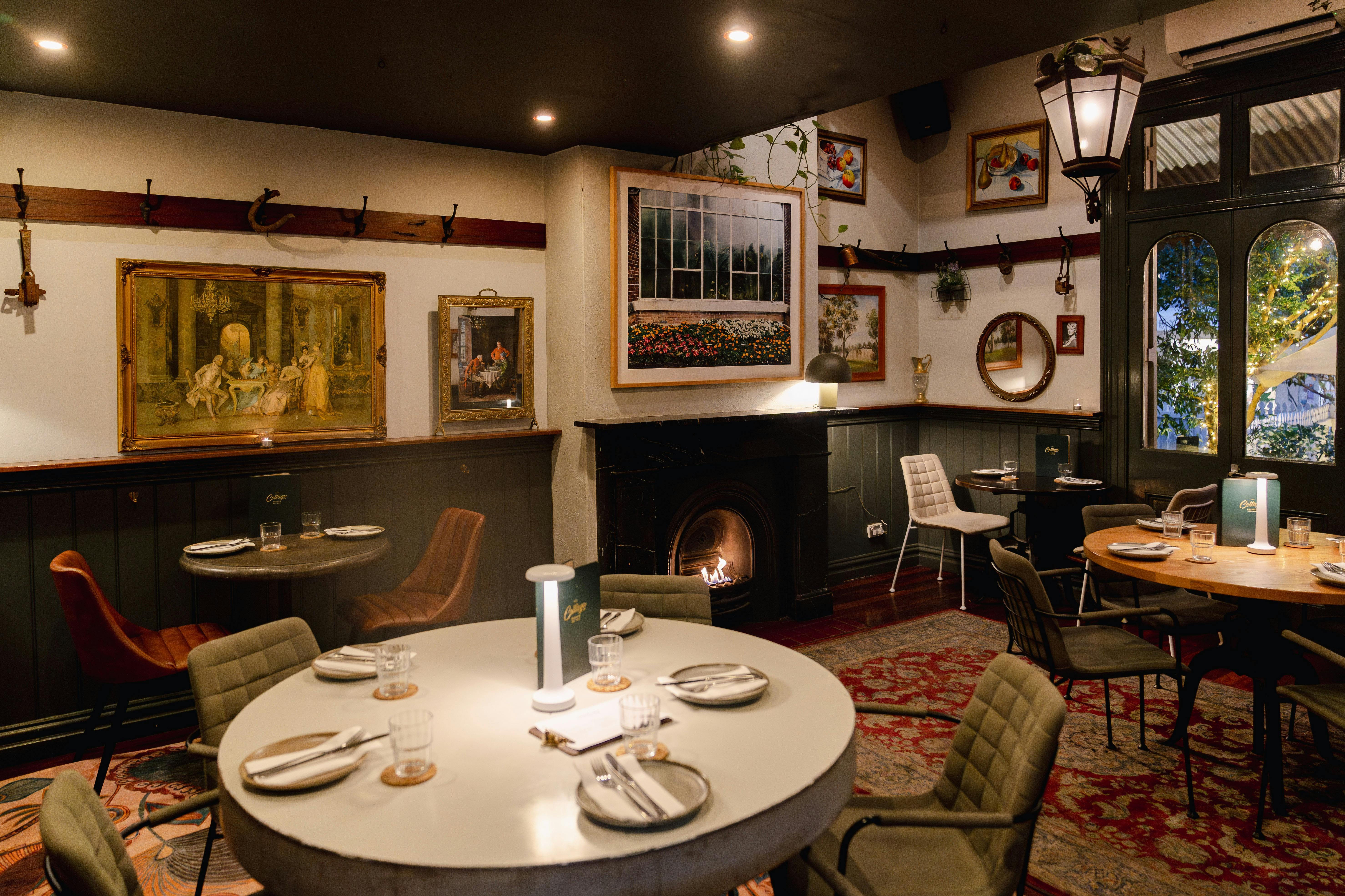 A warmly lit, cozy restaurant interior featuring an eclectic, vintage aesthetic.
