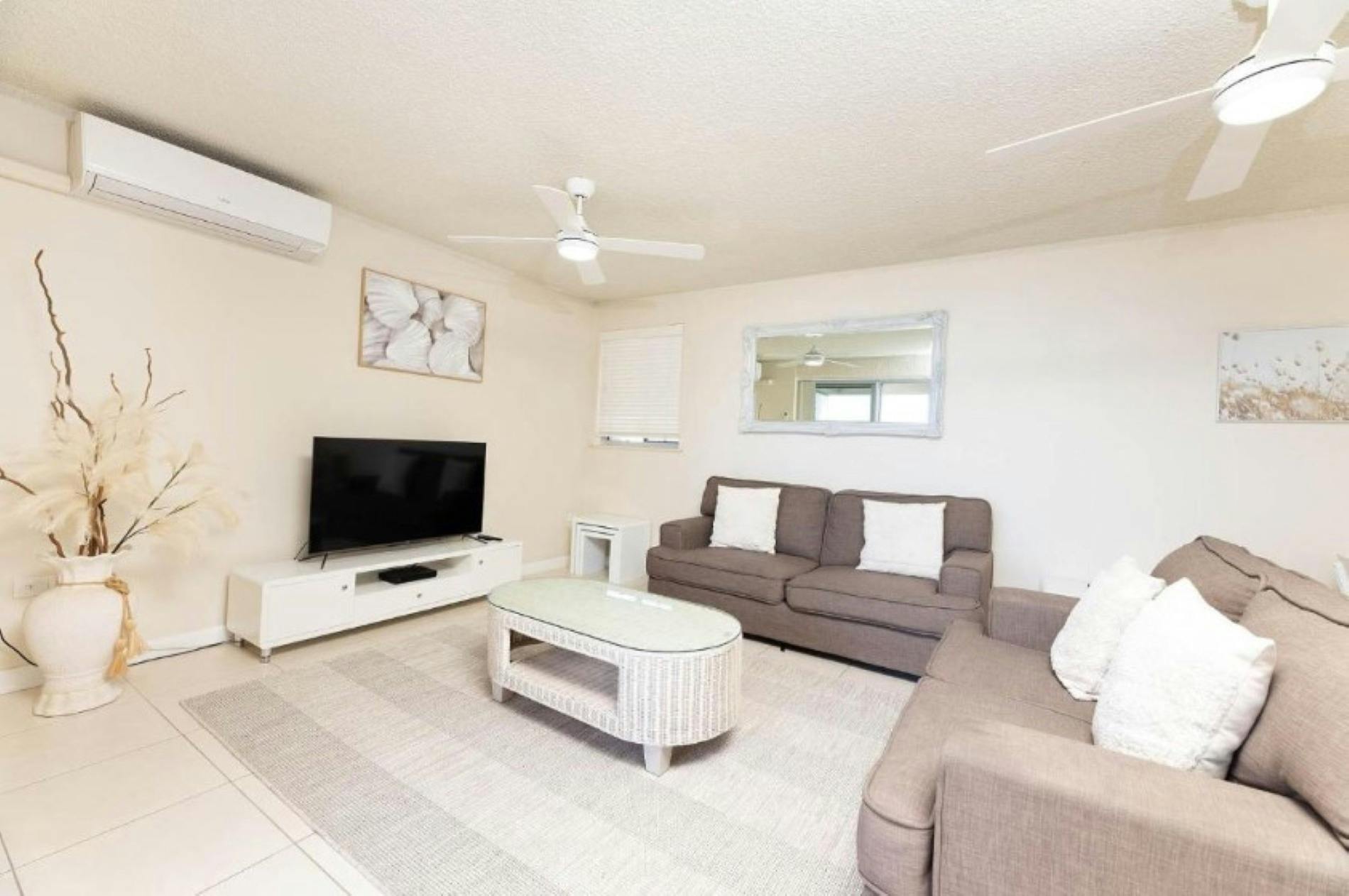 Klimatisiertes Wohnzimmer mit TV, Lounges und Küstendekor