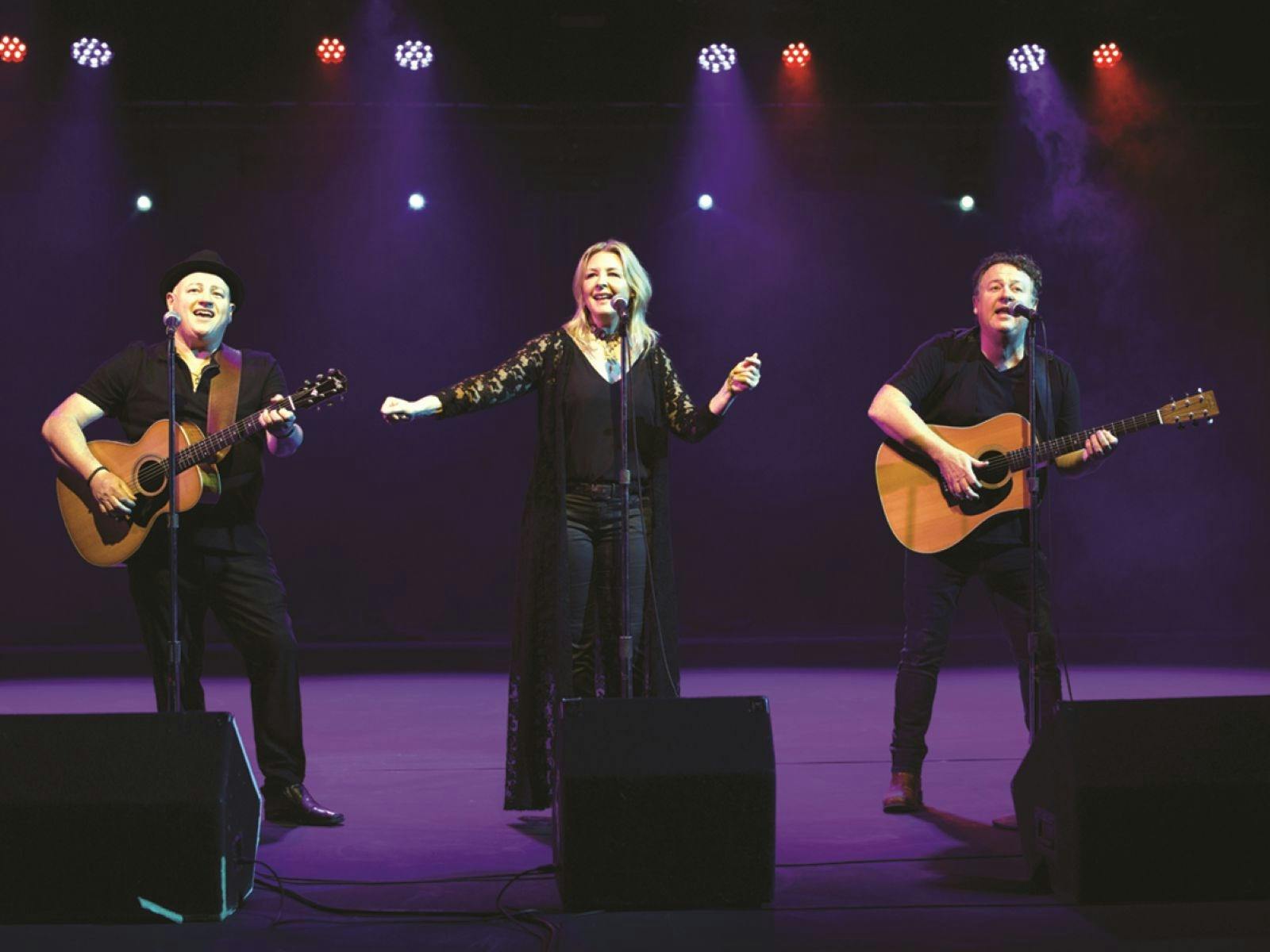 Three people performing a musical act on stage