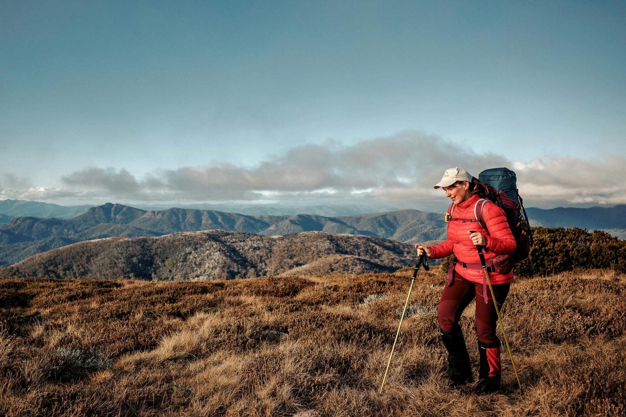 A hiker high in the mountains with uninterrupted views of the surrounding mountains