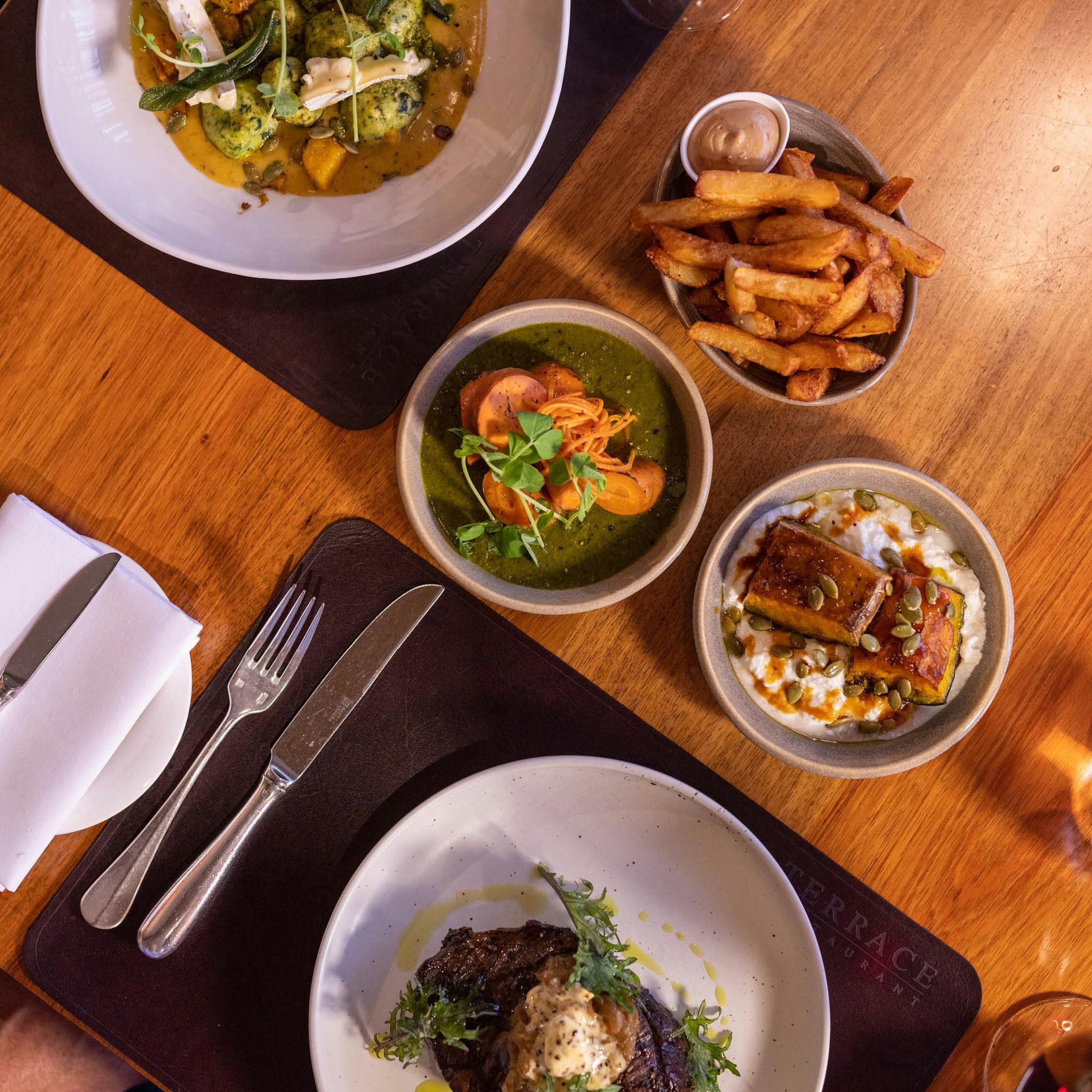 Plates of food, set for a meal at a table