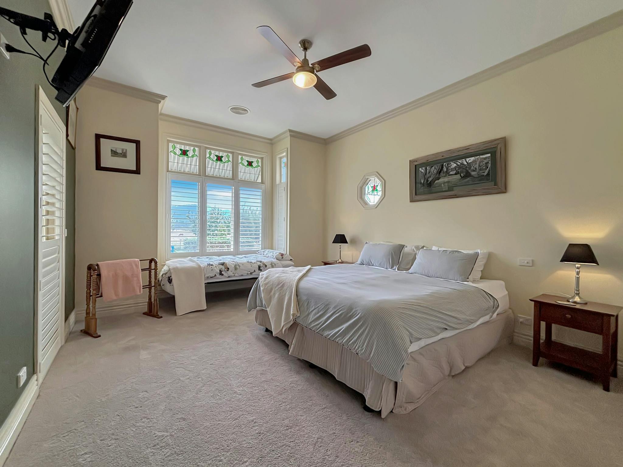 Del  1 with bed, bed side table, lamp and seating area near the window