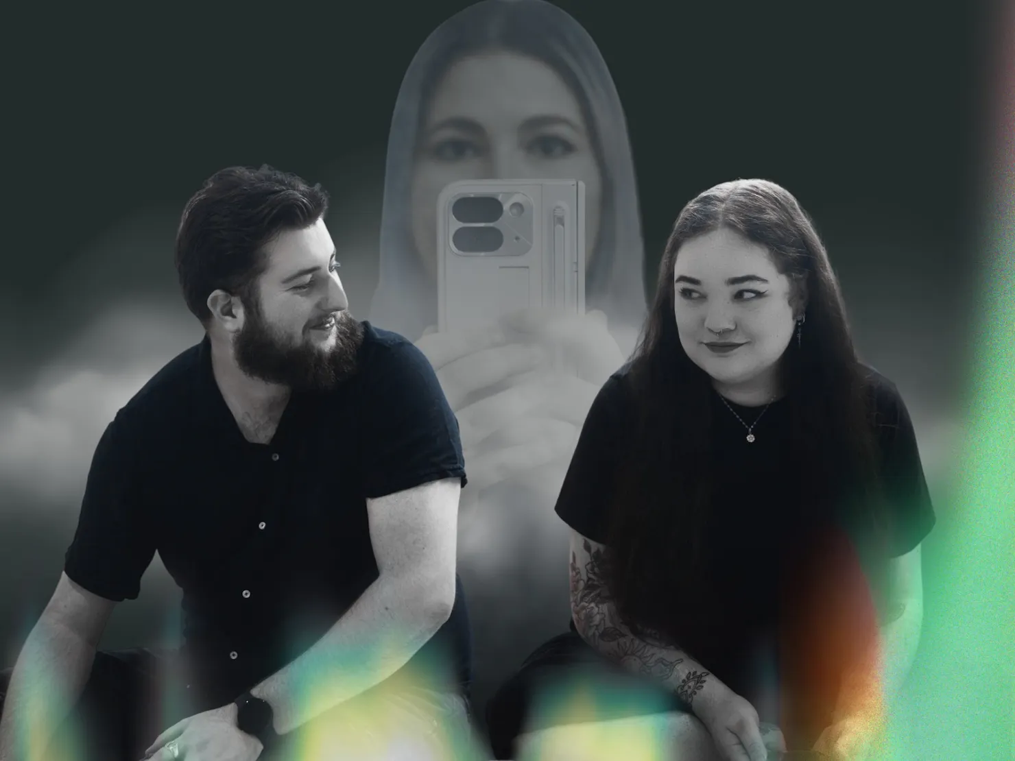A couple sit smiling at each other. Behind them, a girl is holding a phone, hidden by smoke.