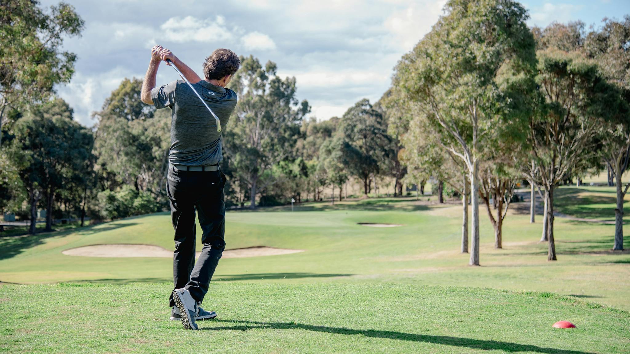 Man hitting golf ball on the golf course at Metung Country Club