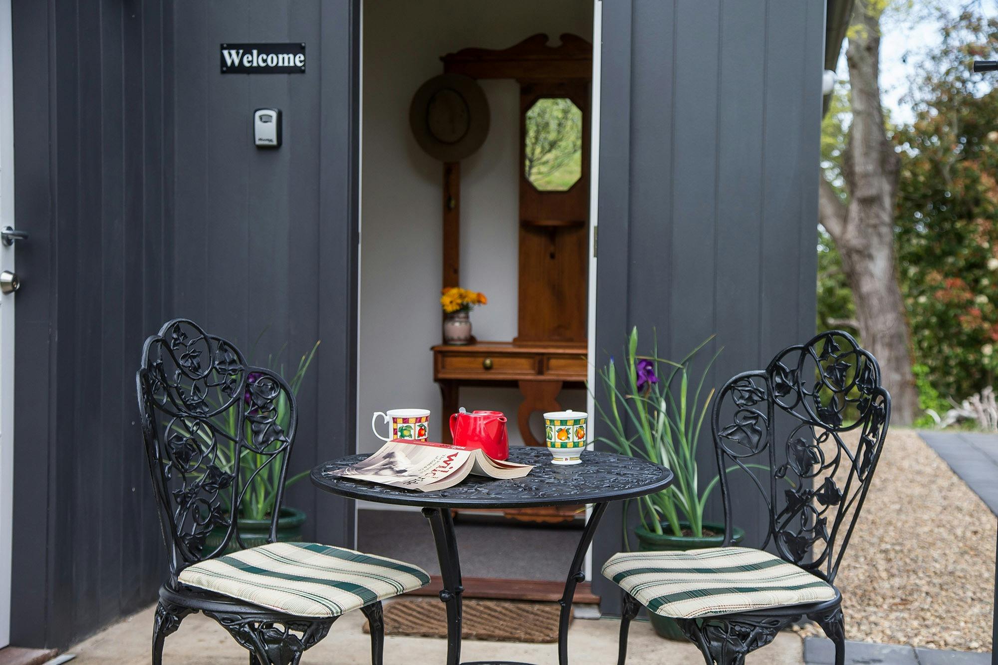 Outdoor furniture with coffee cups in front of front door to Loft