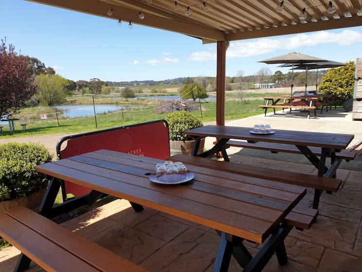 The outdoor tasting area with covered seating area, views of the dams, a deck with picnic tables.