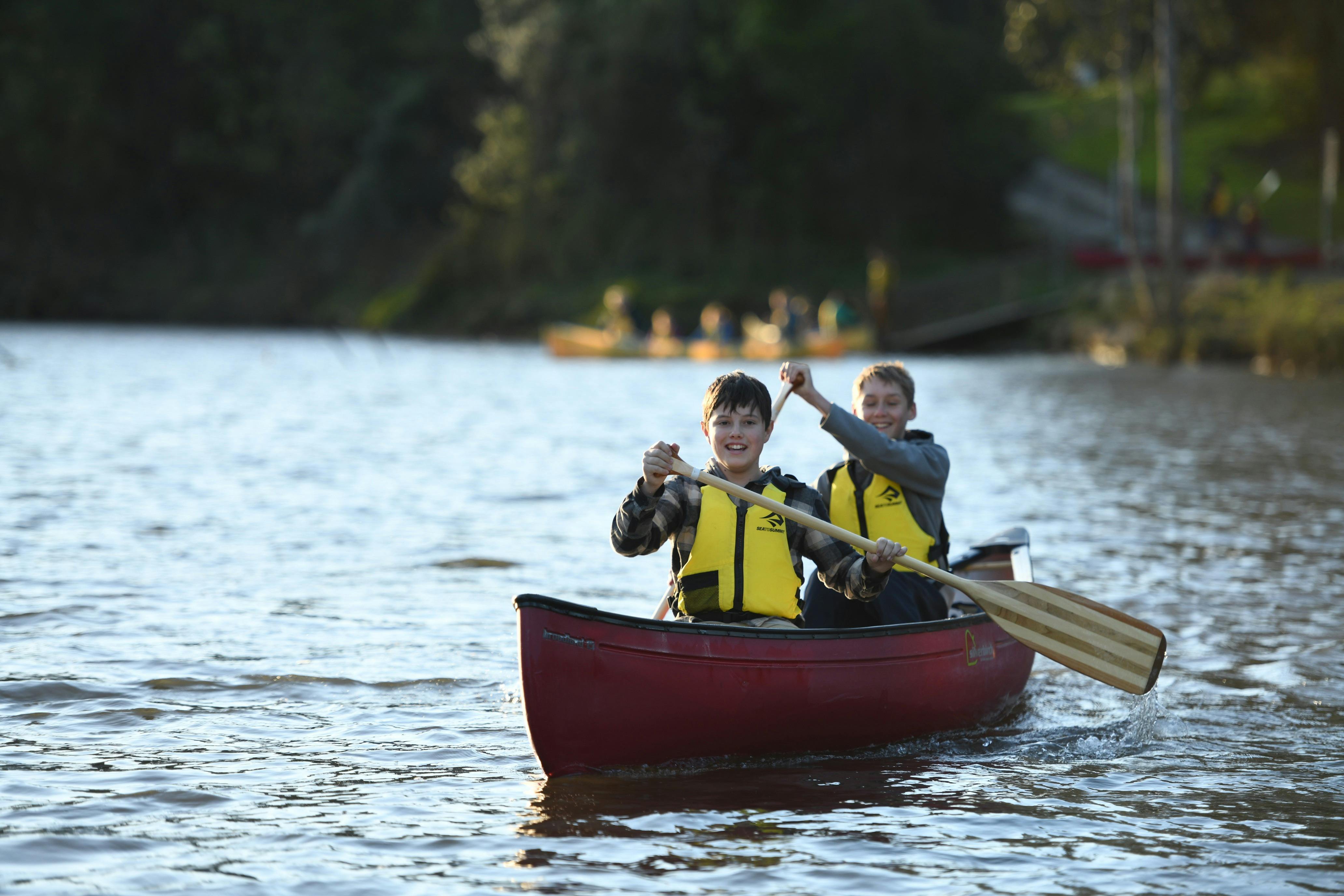 two smiling boys canoeing