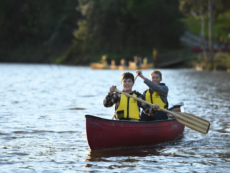 two smiling boys canoeing