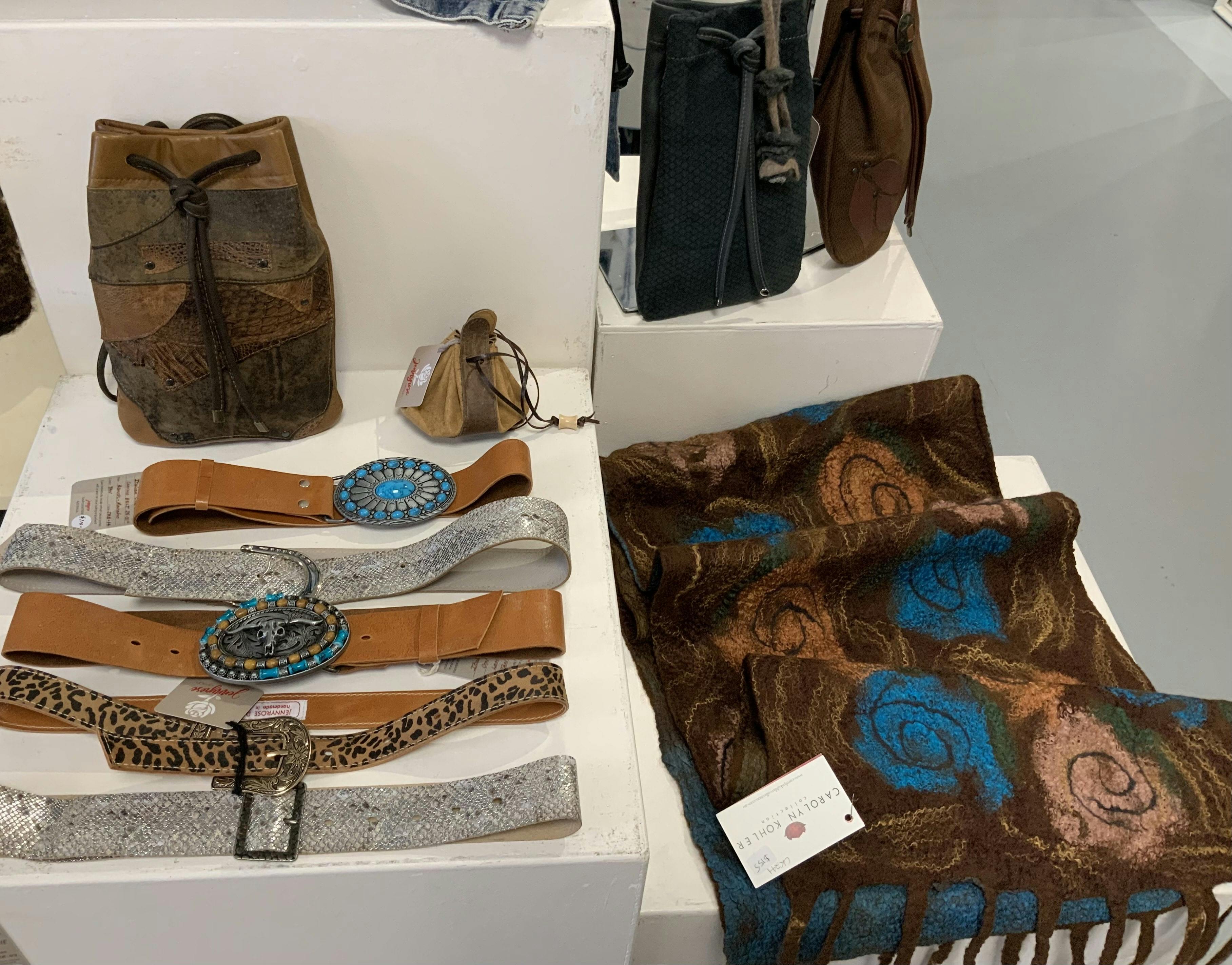 Photo of inside the gallery, showing handmade leather beltas and hand-felted wooolen scarf