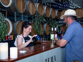 lady serves wine at Zema Estate pizza event