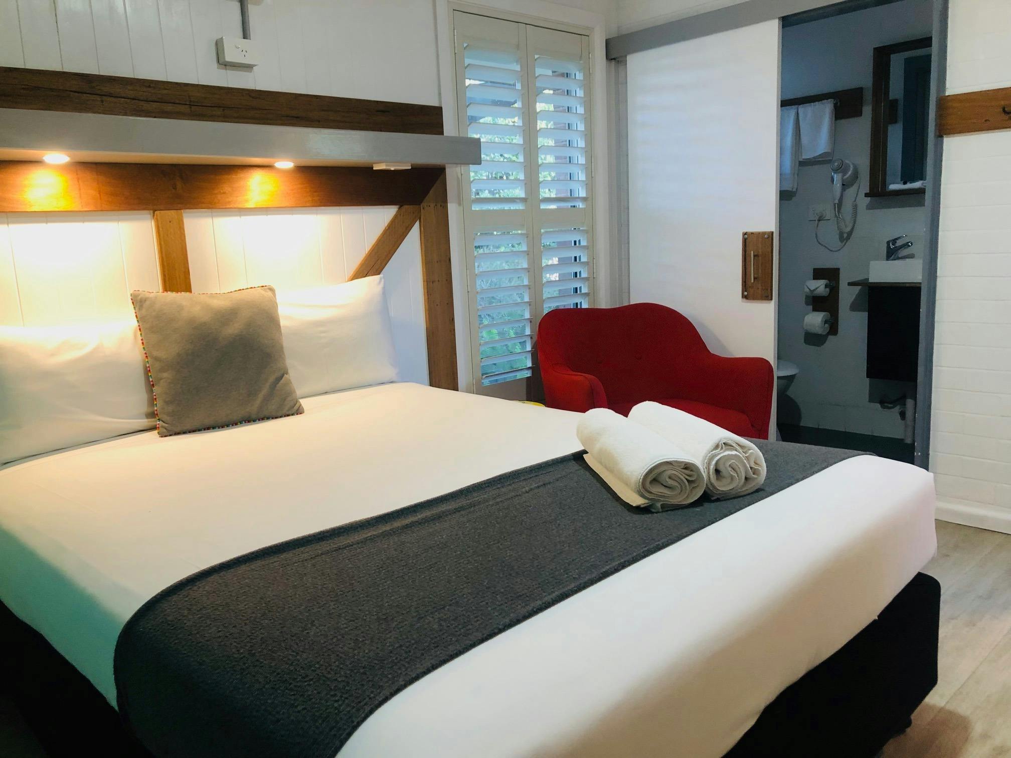 손으로 만든 목재 침대 머리판이 있는 퀸 사이즈 침대