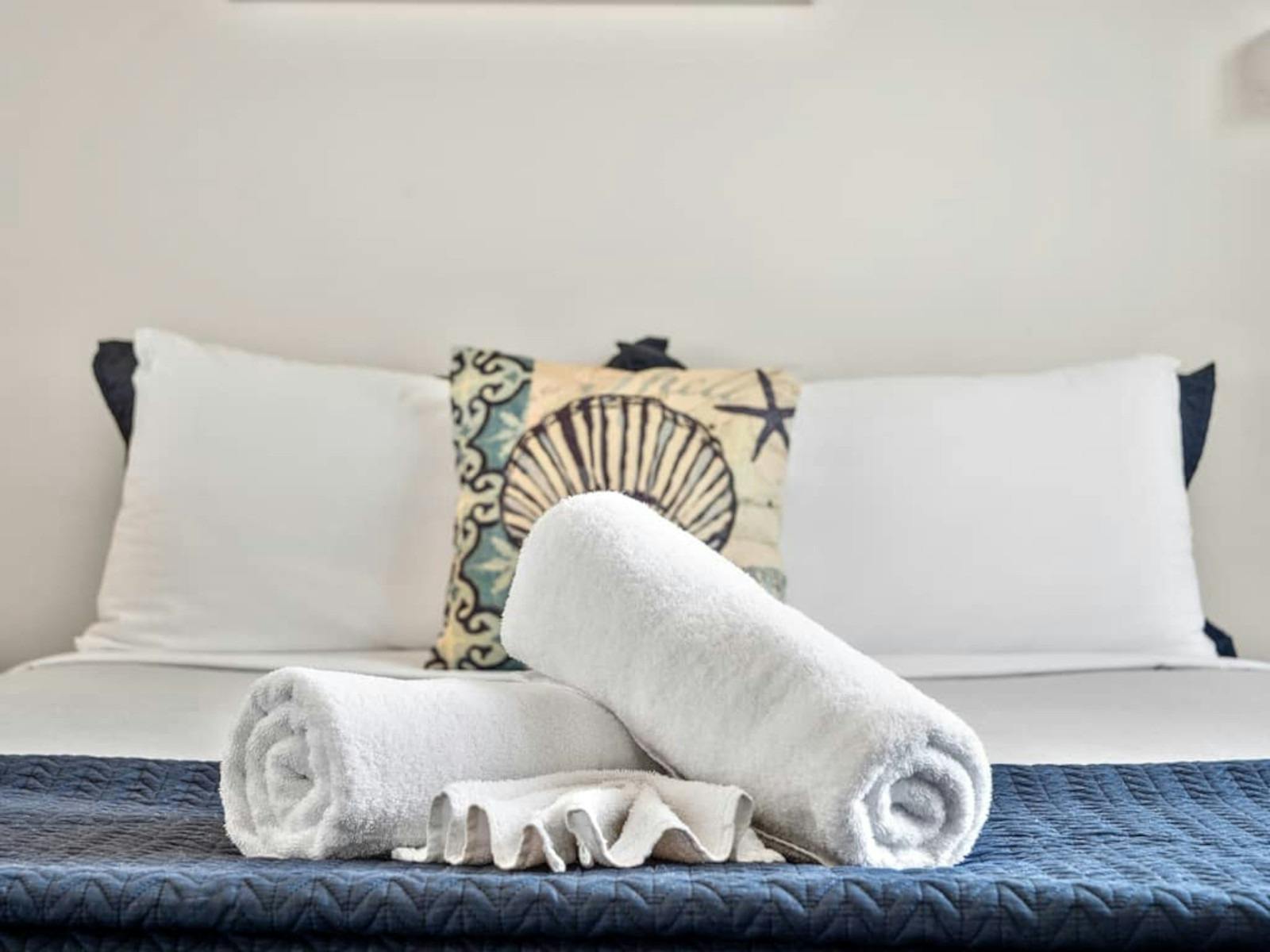 Towels and cushions on bed