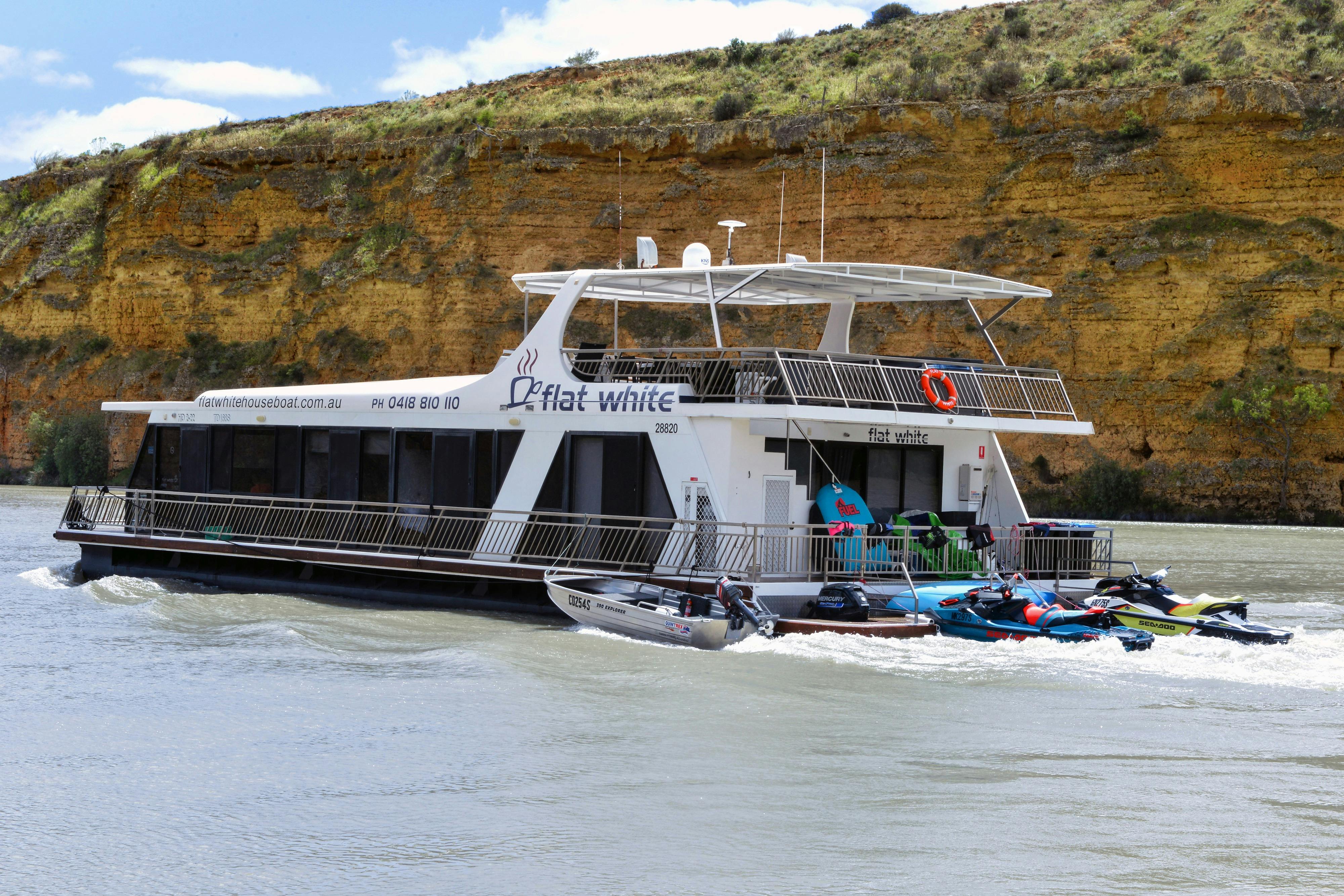 Flat White Houseboat with Cliffs in background