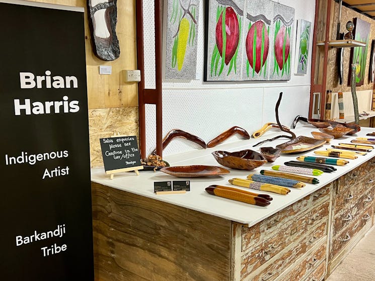Brian Harris Indigenous artist sign with selection of paintings and carved artifacts
