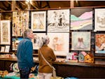 People looking at art hanging on the wall