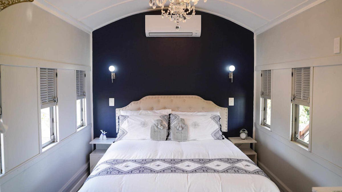 Elegant train carriage bedroom with a plush bed, chandelier, and vintage charm in a peaceful setting