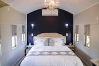 Elegant train carriage bedroom with a plush bed, chandelier, and vintage charm in a peaceful setting