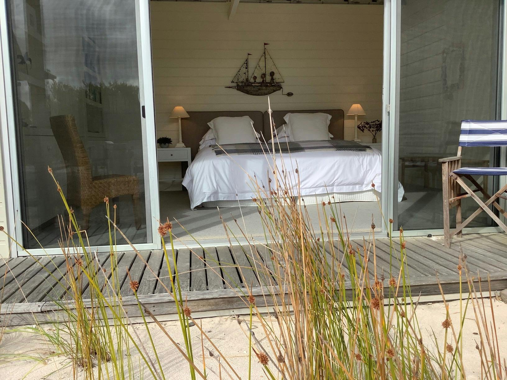 This spacious super king  bedroom looks across the central deck  into the dunes
