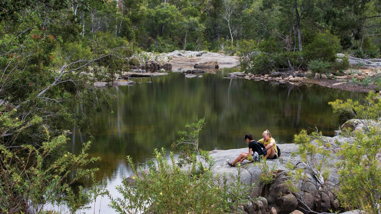 Walkers sitting near rockpool, Alligator Falls track.