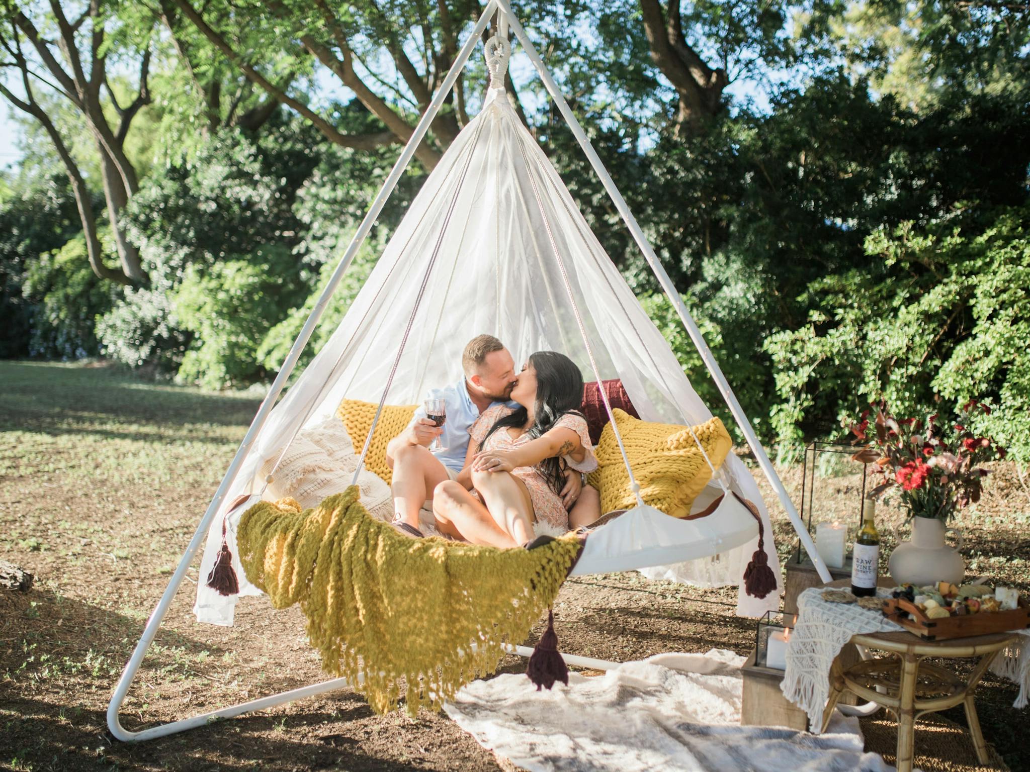 A couple enjoying a romantic picnic in a hanging tiipii pod at Soul Nook A couple enjoying a romantic picnic in a hanging tiipii pod at Soul Nook