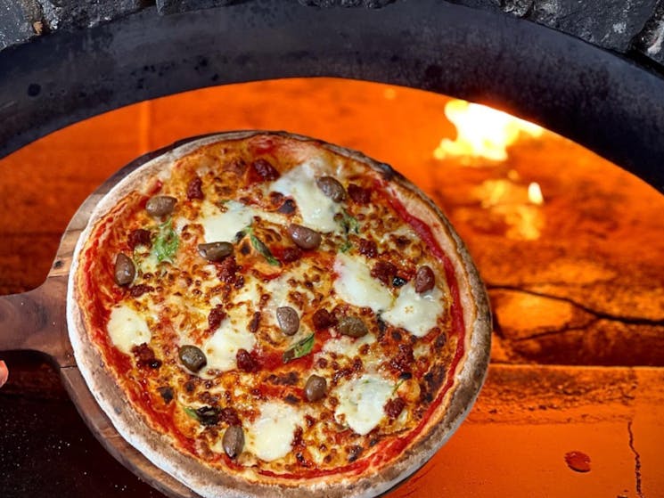 a pizza coming out of a pizza oven