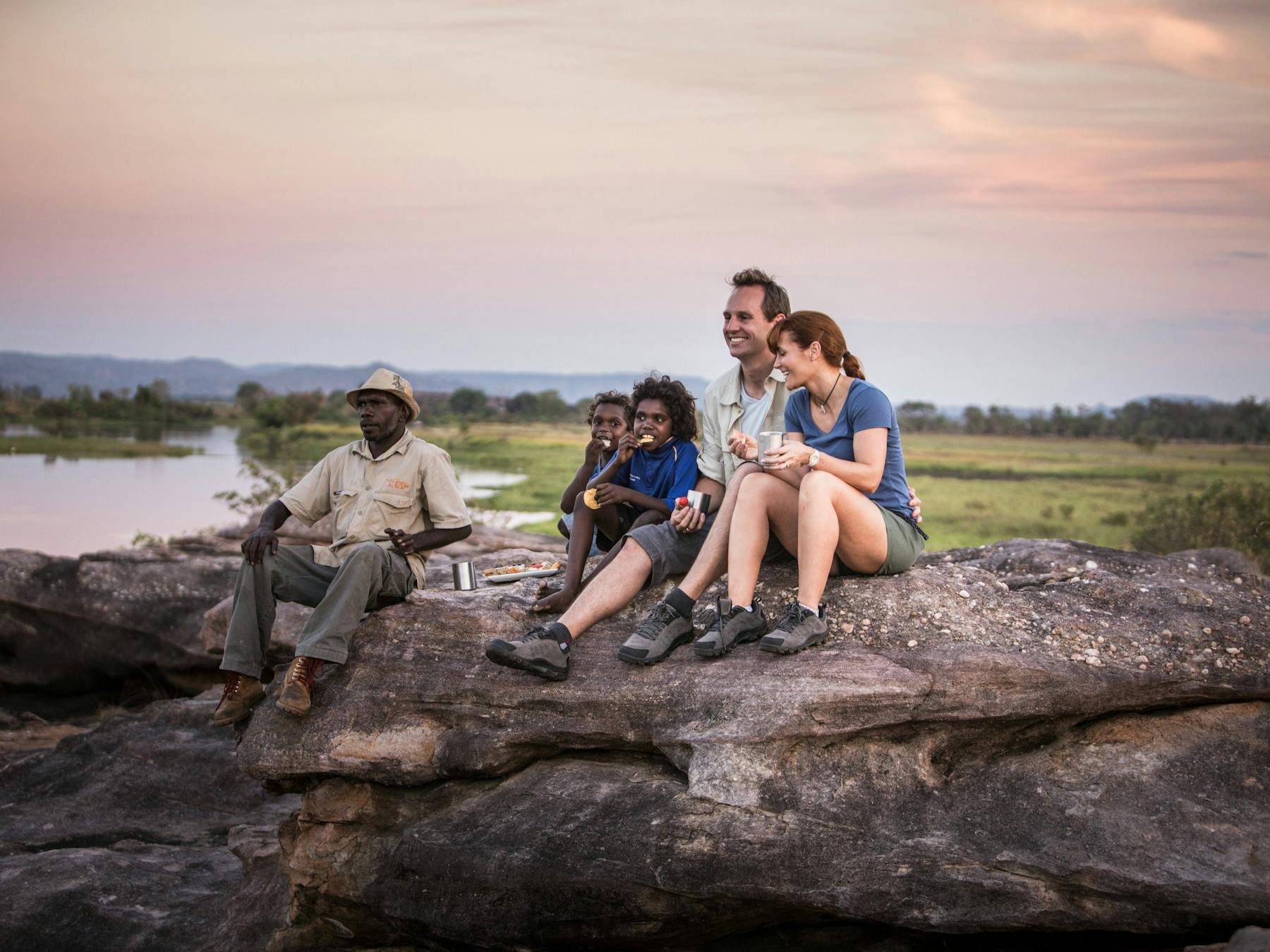isitors looking over the Kakadu landscape with an Aboriginal guide.