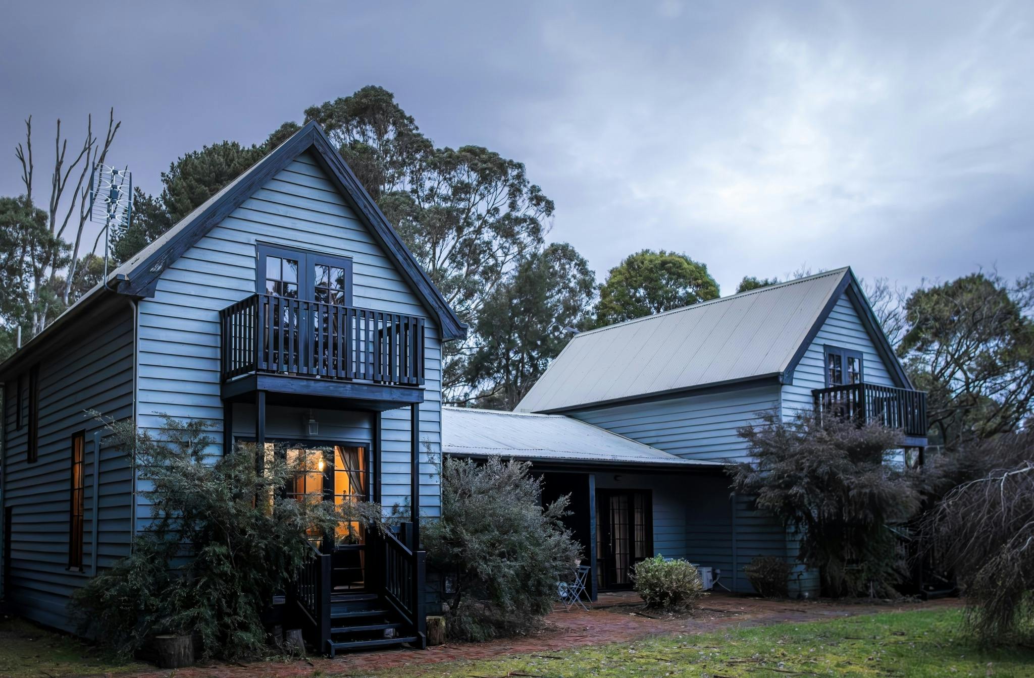 Exterior of The Quarters Strahan, showing a blue timber building with four self-contained,apartments