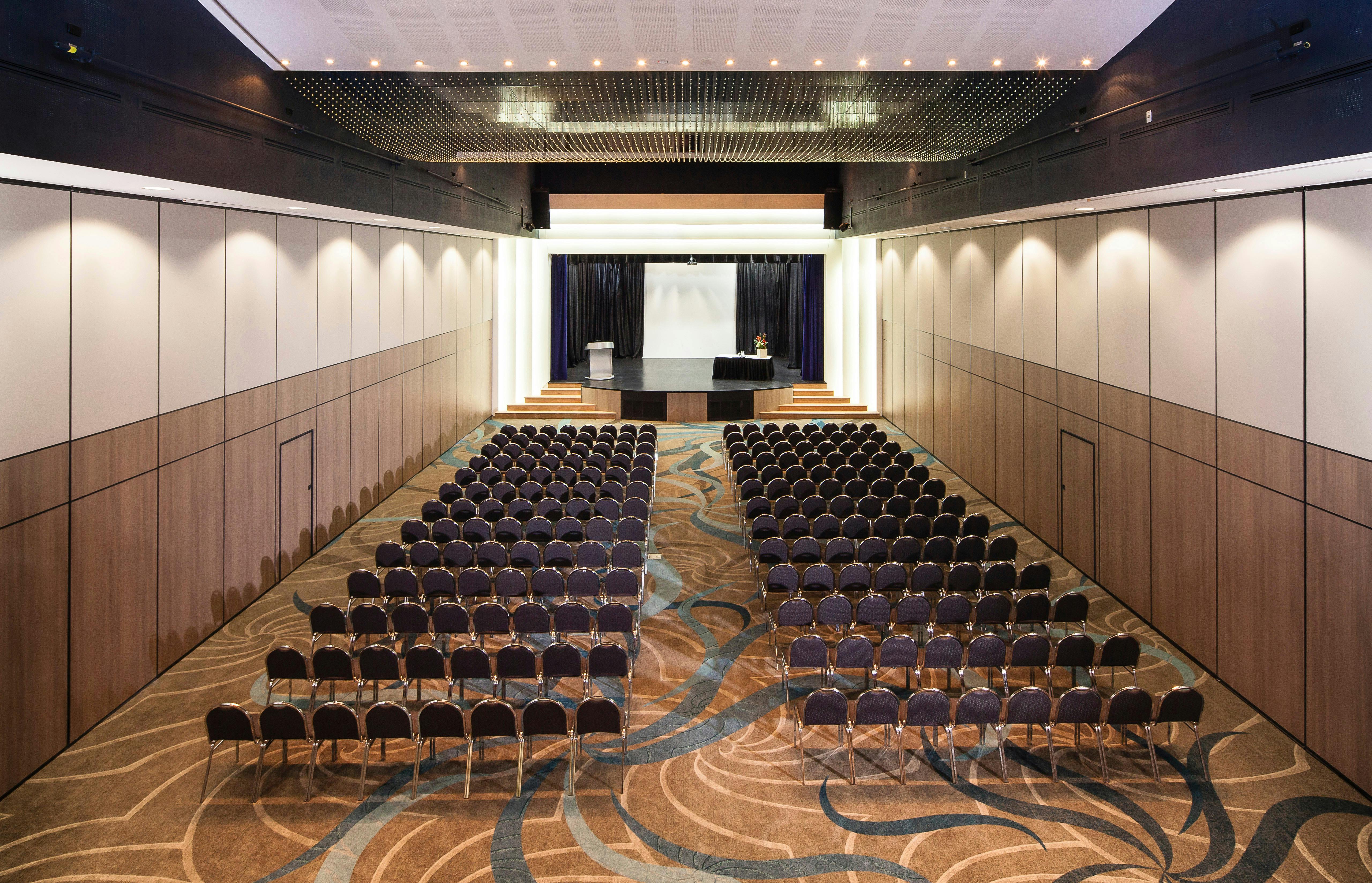 A function room with chairs arranged in rows, prepared for a seminar