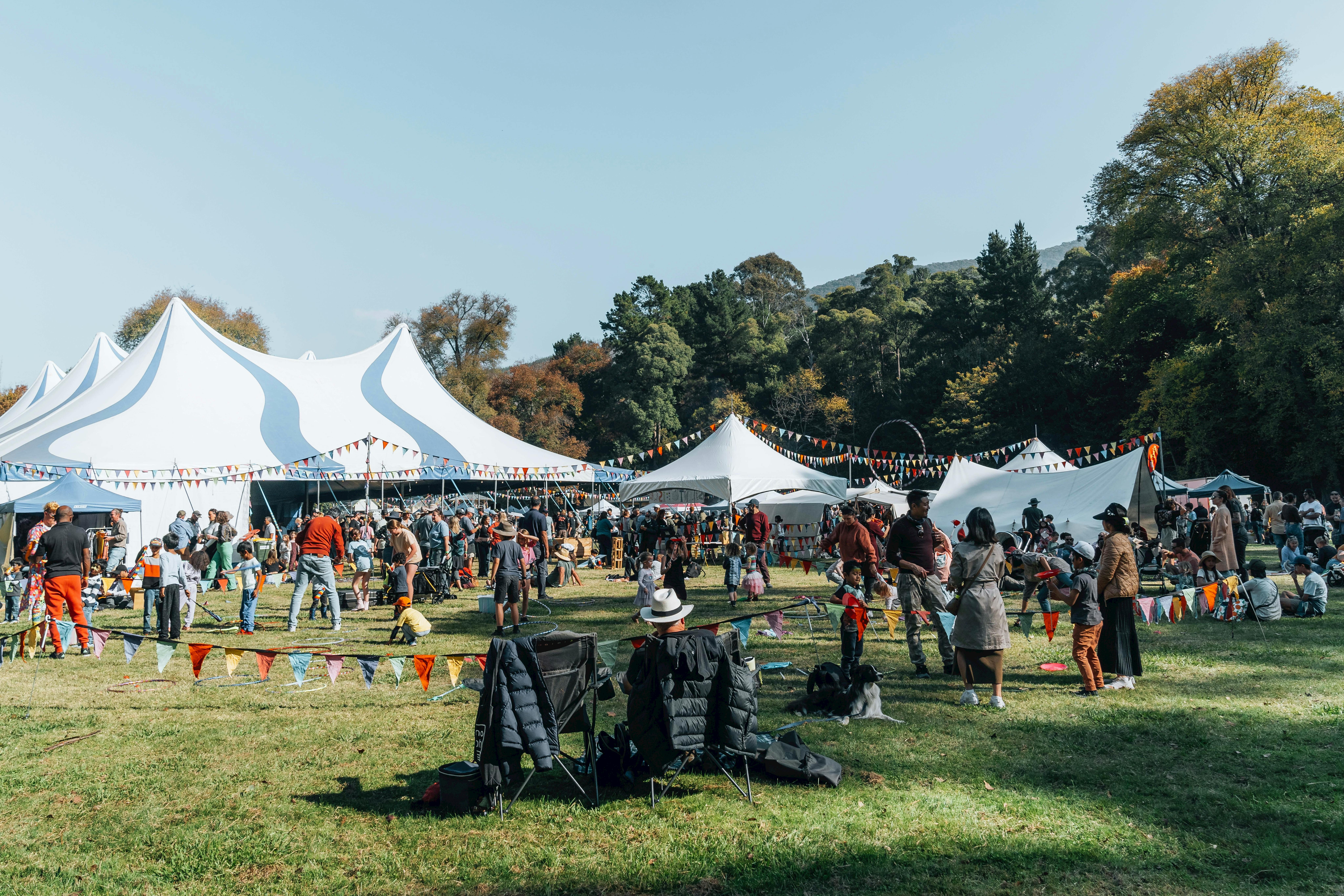 Attendees sitting in chairs and on picnic rugs outside the big top tent.