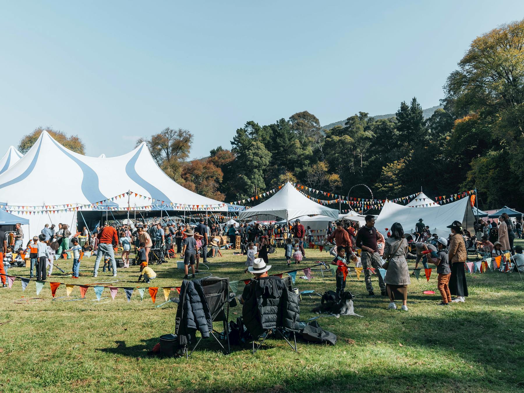 Attendees sitting in chairs and on picnic rugs outside the big top tent.