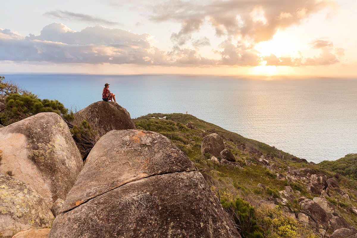 Visitor sitting on boulder at Summit of Fitzroy Island.