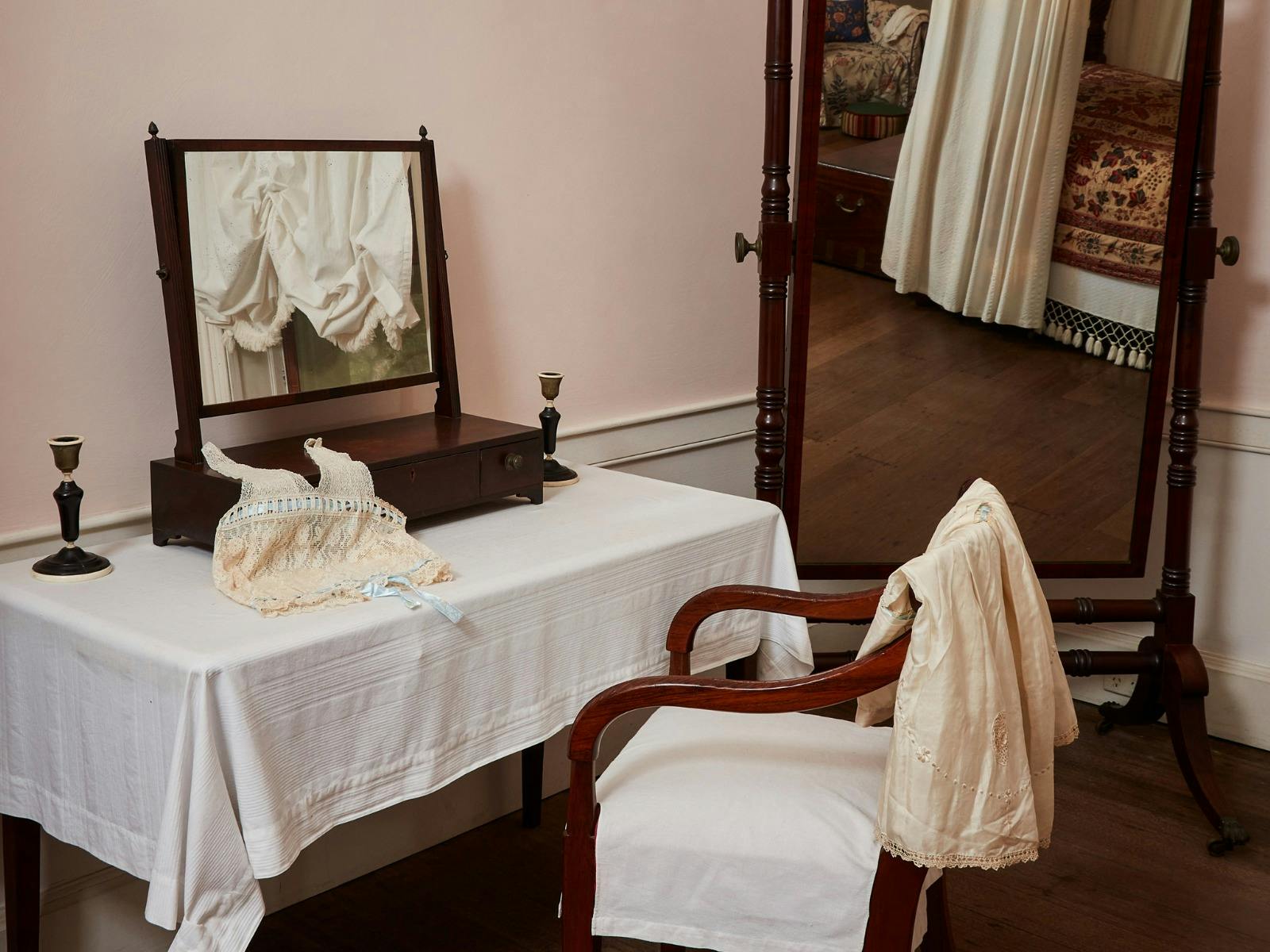 Historic underclothes rest over the arms of a wooden chair