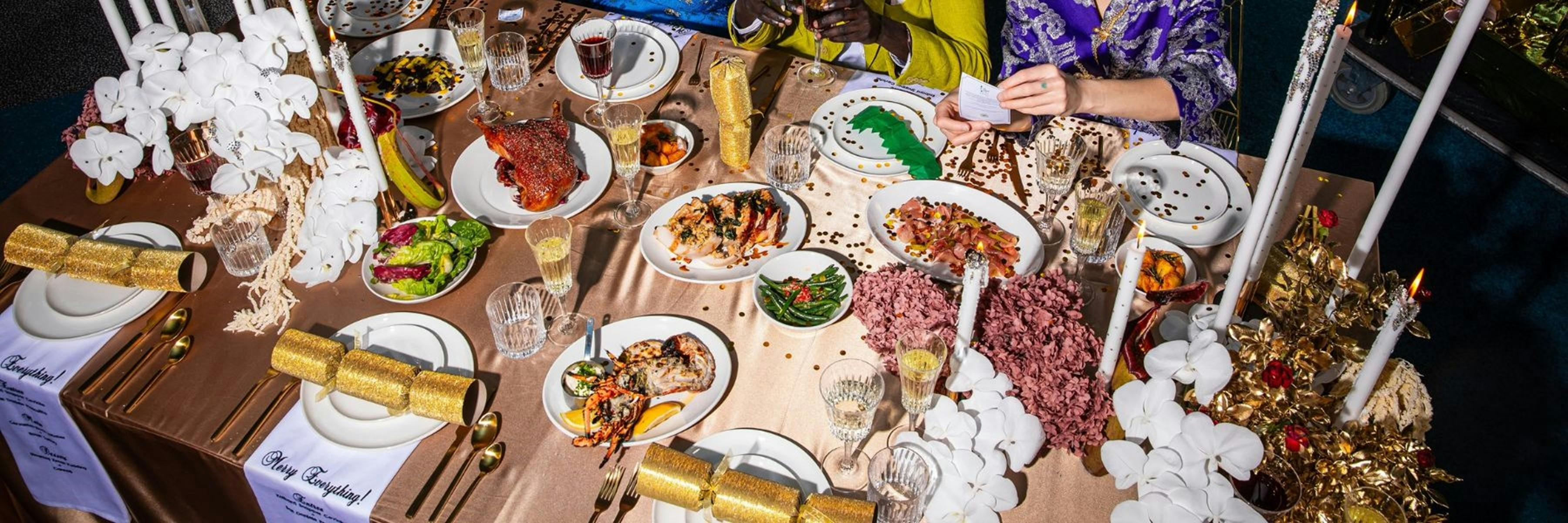 Platters of food and drink glasses spread out on beige table