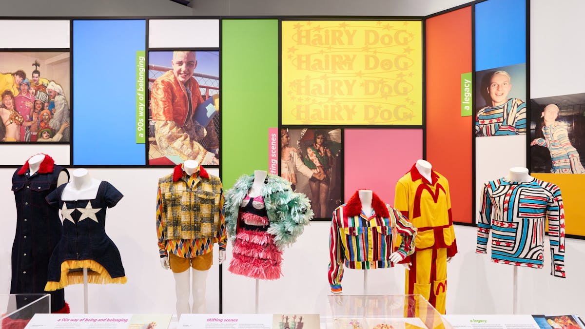 Bright, fashionable outfits from the 1990s displayed against a colourful backdrop.