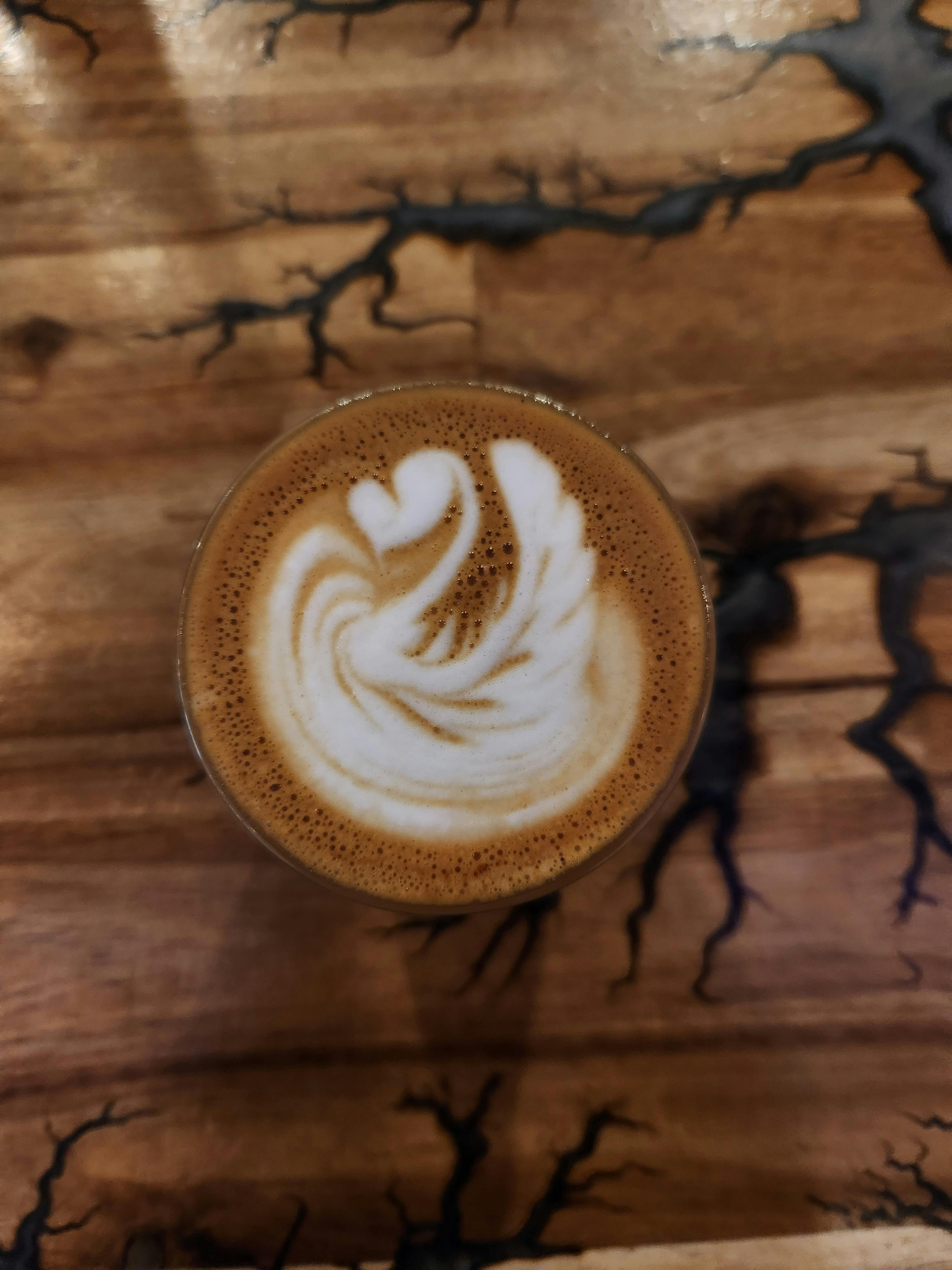 A picture of a piccolo latte with a swan pattern poured into it