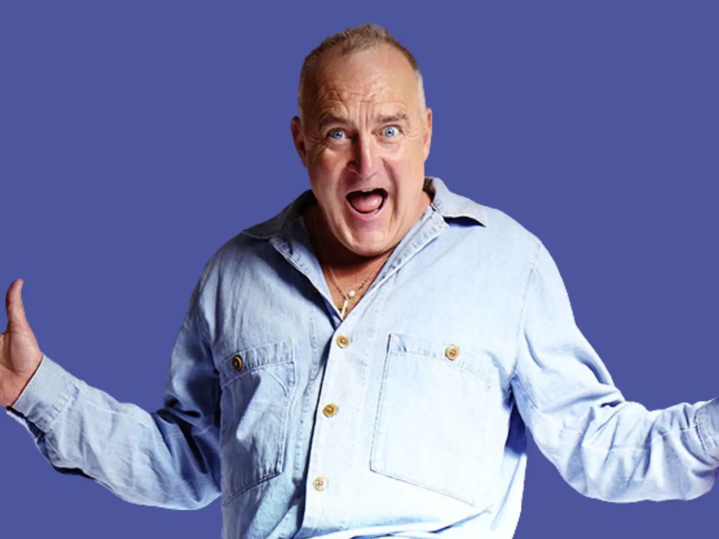 Jimeoin in a blue shirt with his arms out and mouth open