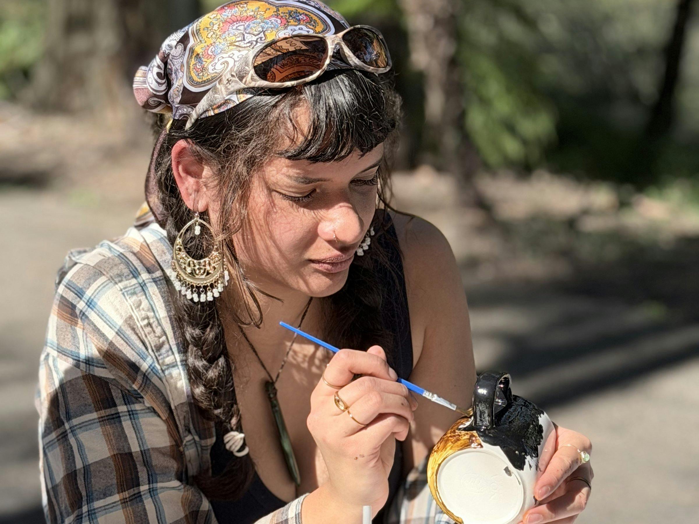 Guest hand-painting a ceramic cup at a NOA Matcha workshop
