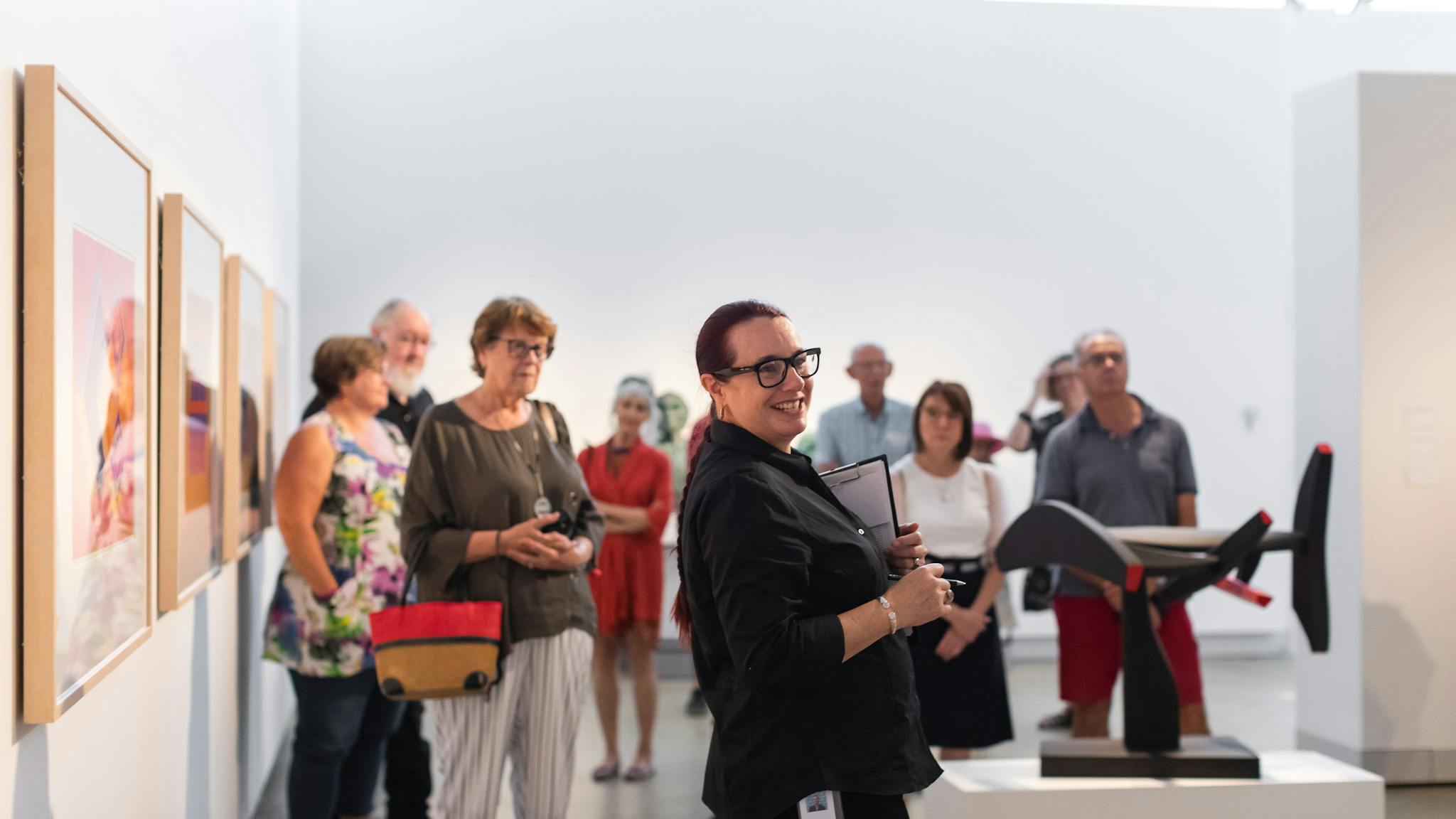 Large group of people participating in 'Marc Clark: A life in art' exhibition tour