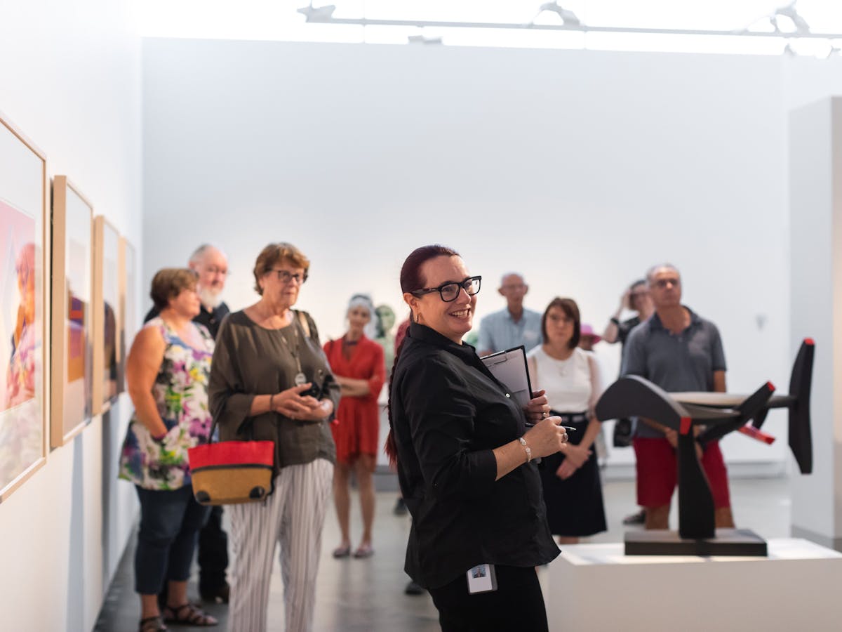 Large group of people participating in 'Marc Clark: A life in art' exhibition tour