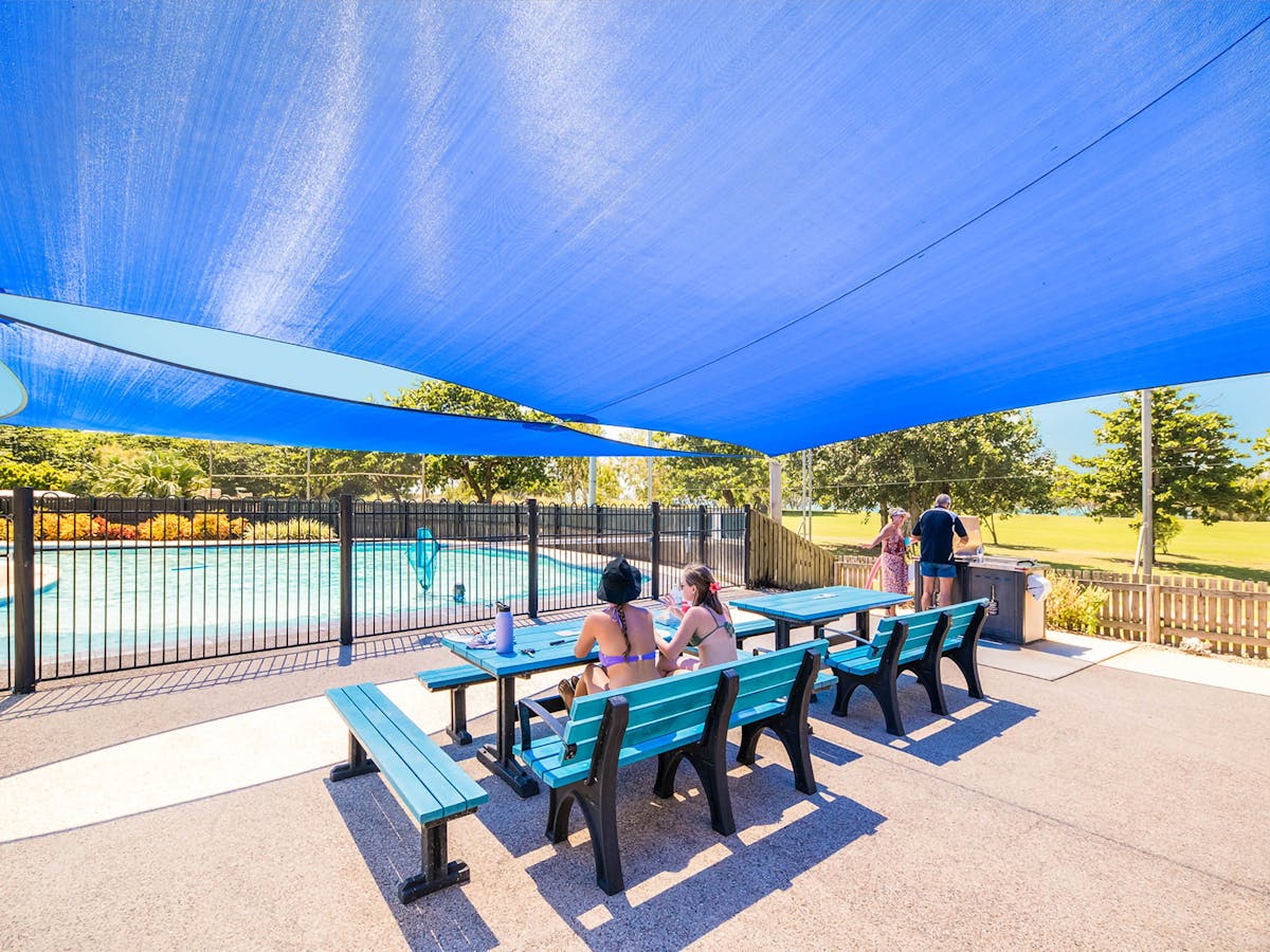 Outdoor seating and Pool area. The area is surrounded by gardens and camping areas.