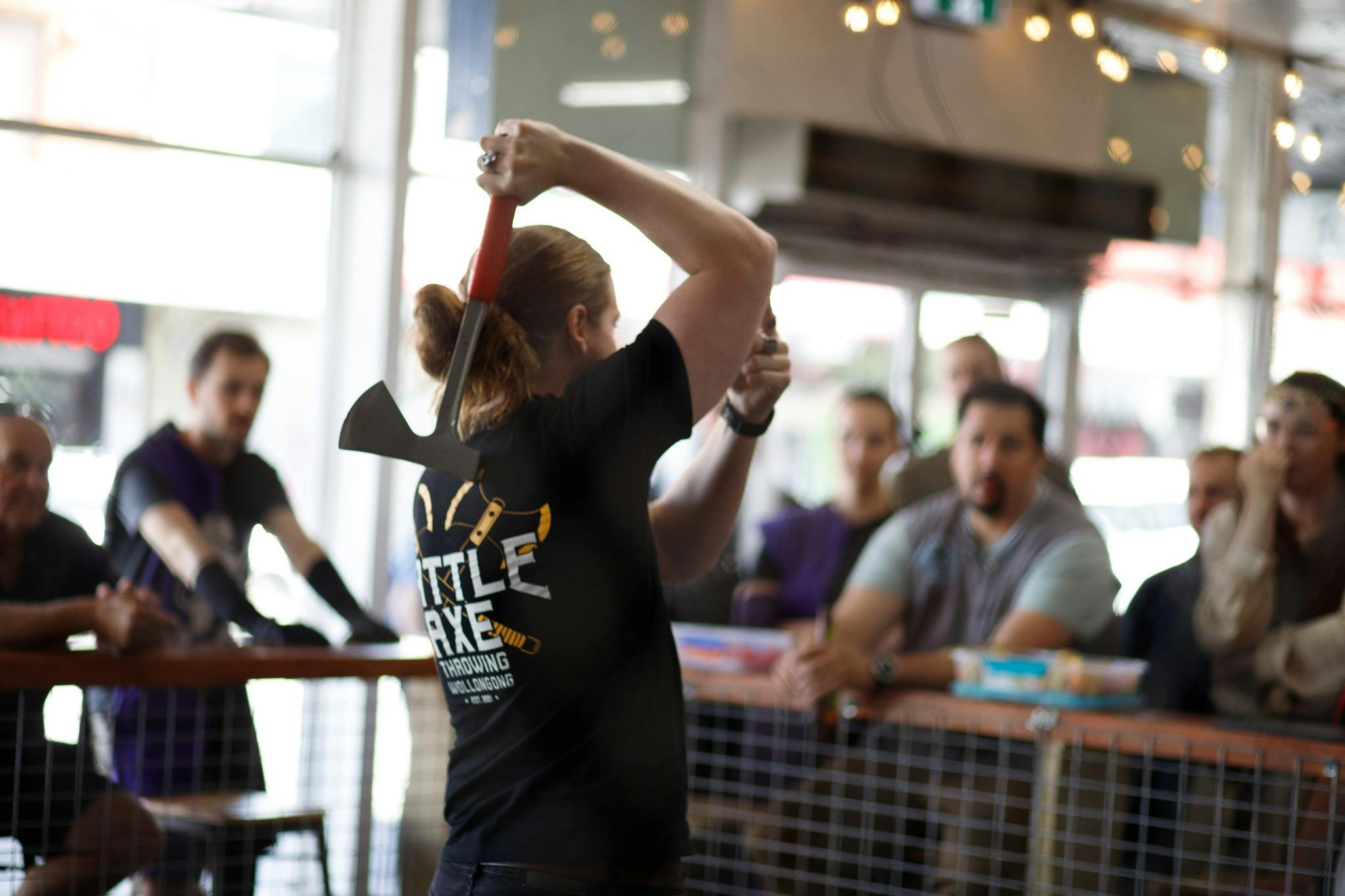 Axe throwing coach helping a group at Battle Axe Throwing Wollongong